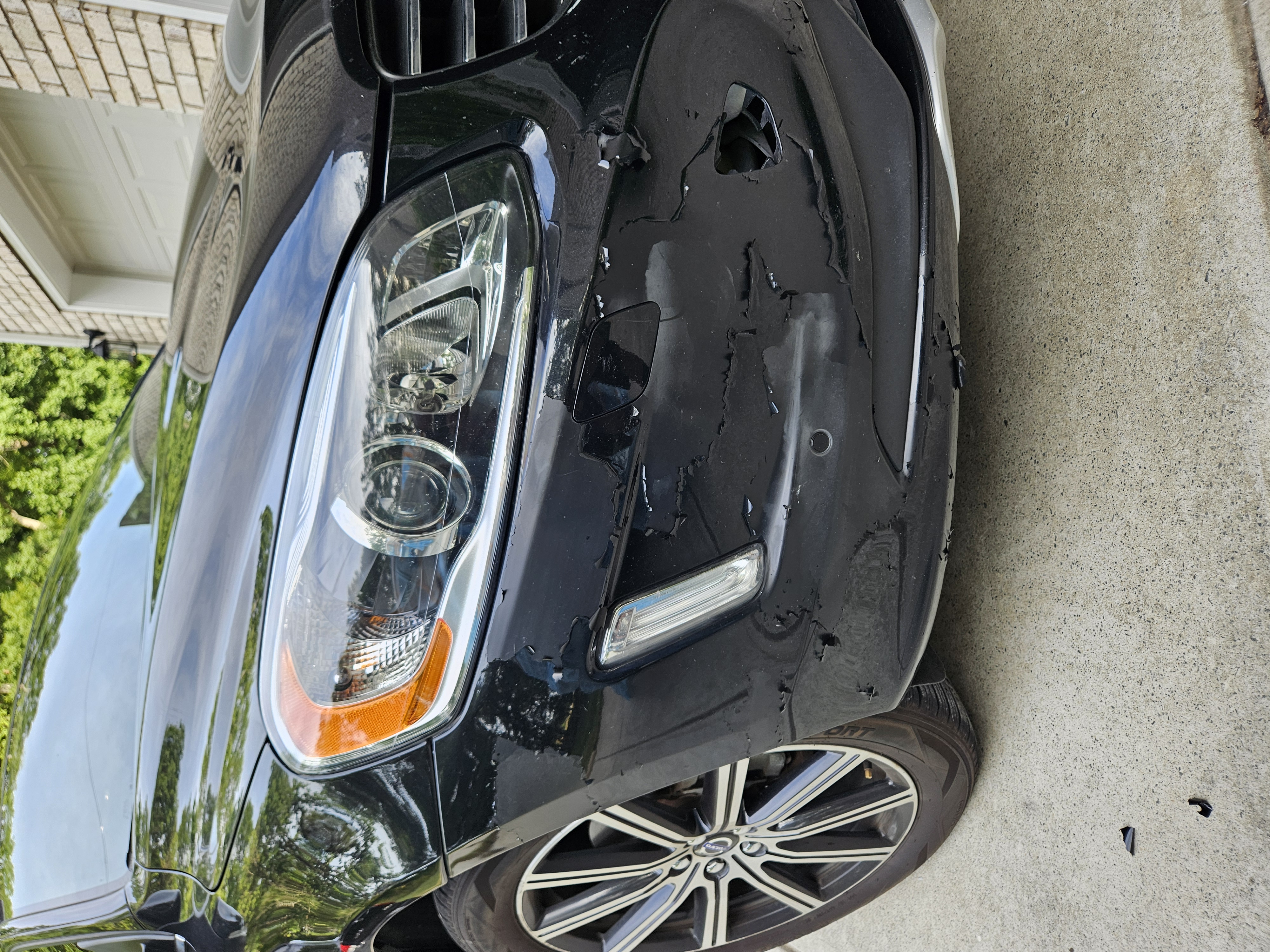Black SUV front bumper with extensive paint chipping prior to refinish — example of bumper repair work
